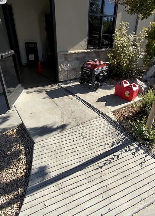 Portable generator, fuel containers, and bundled network cabling outside the Fresno event venue