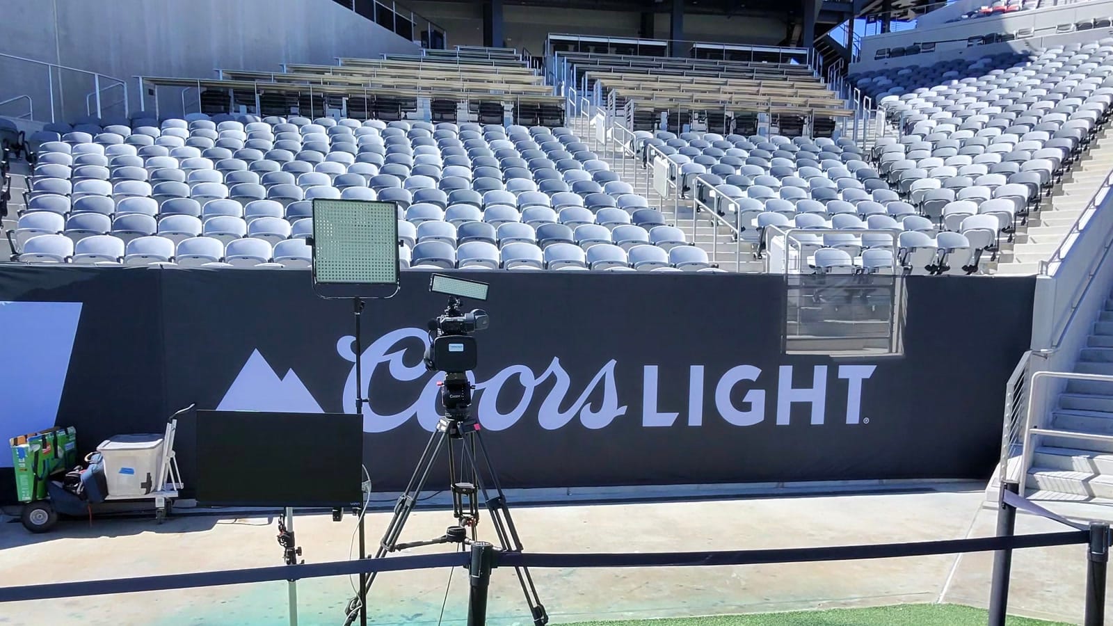 Camera, field monitor, and LED light arranged beside the pitch at Snapdragon Stadium