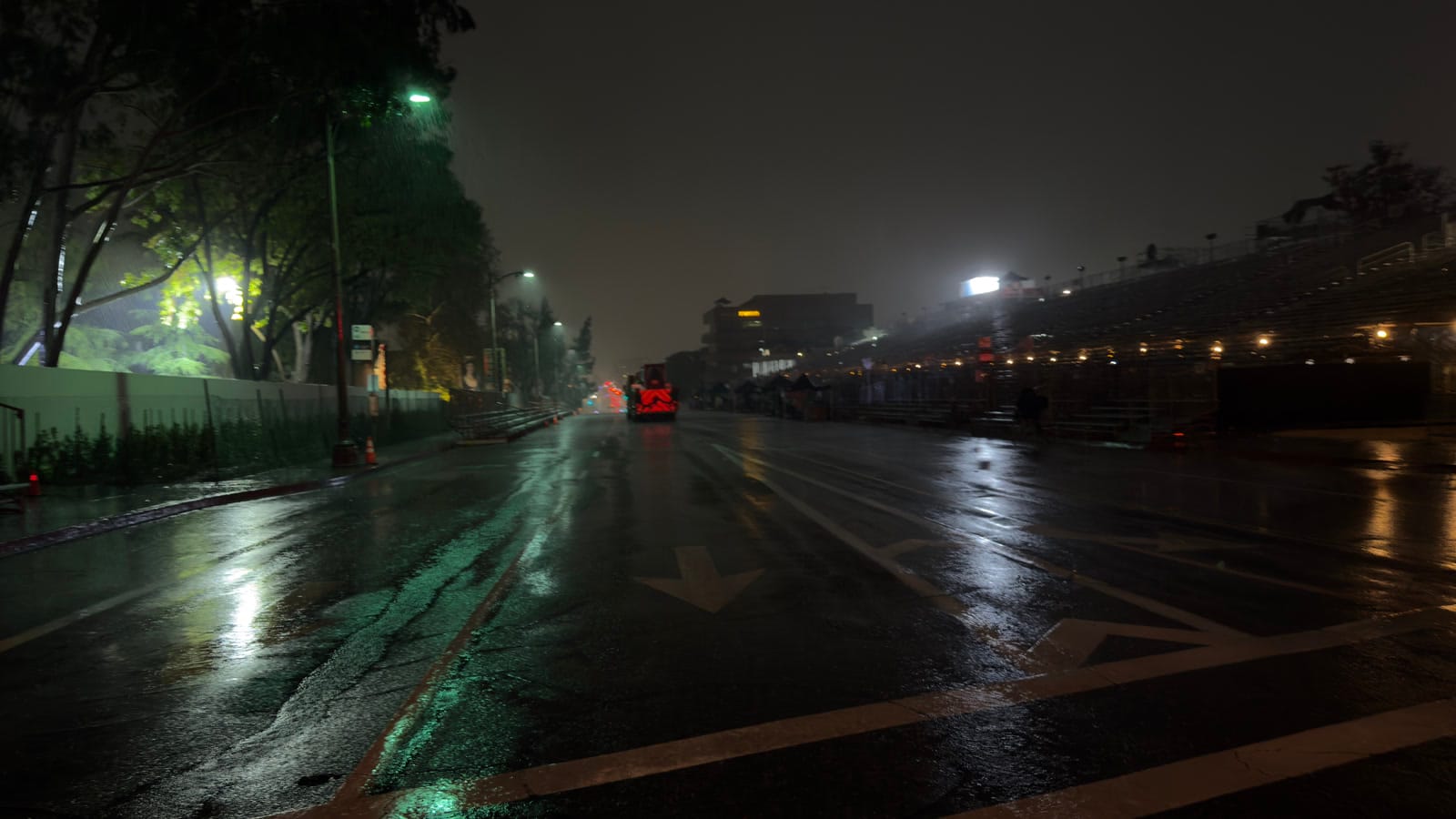 Rain falling on the Rose Parade route and empty grandstands before dawn on January 1, 2026