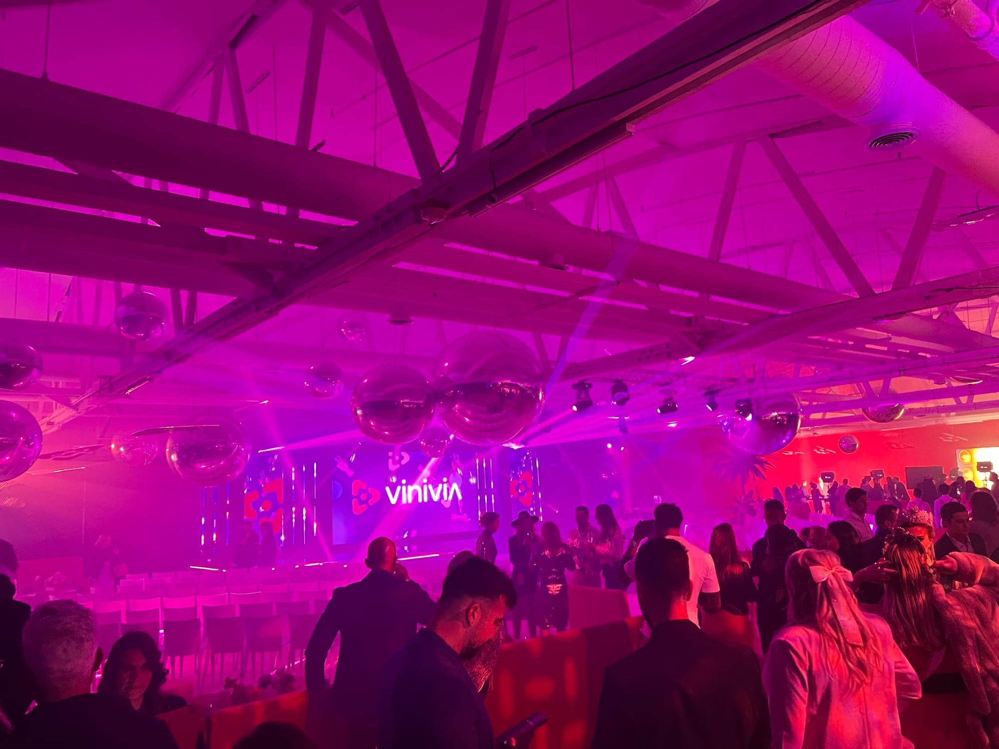 Crowd gathered in the Vinivia Awards room under magenta stage lighting