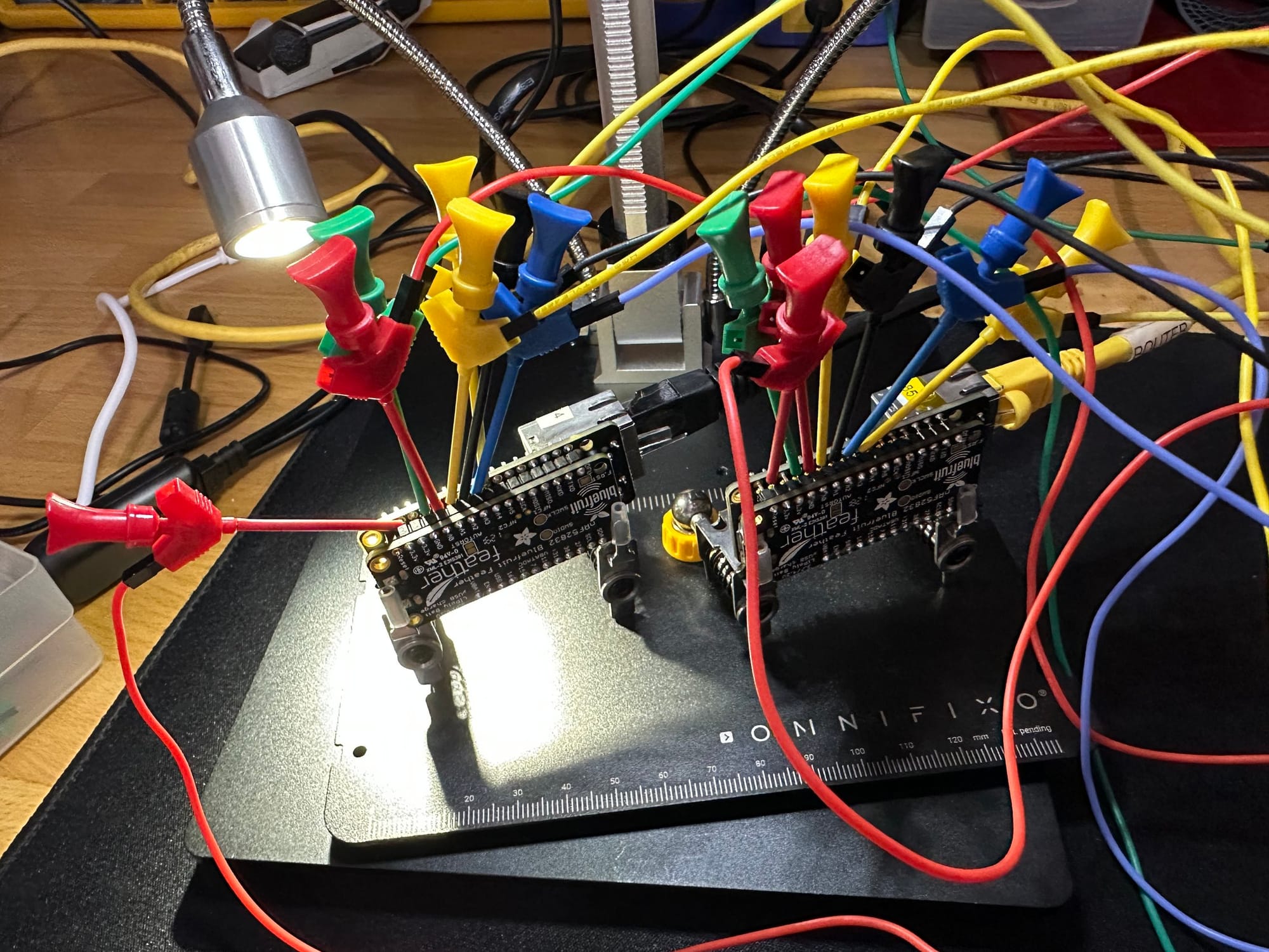 Two microcontroller boards surrounded by test leads during a later bench iteration