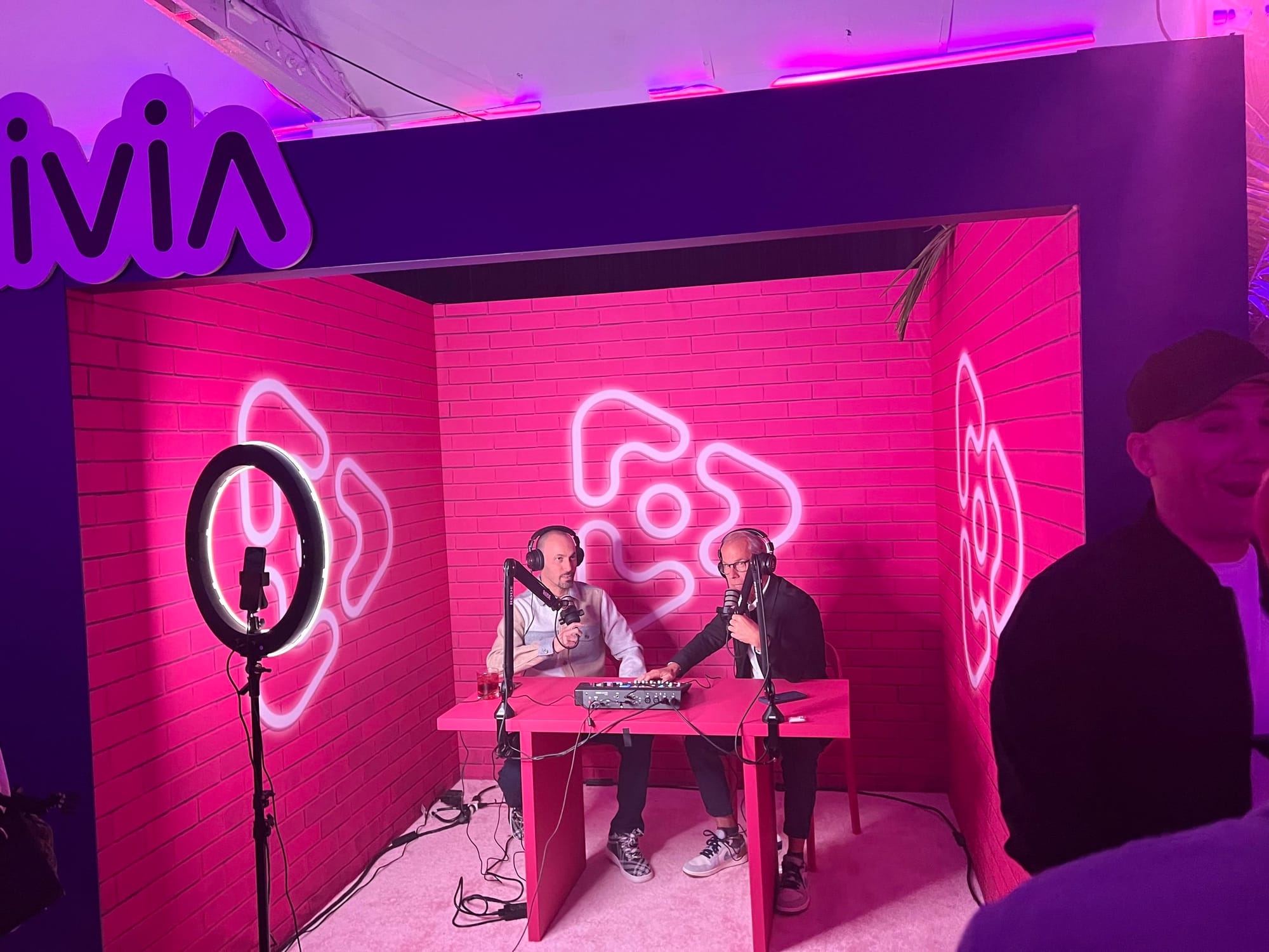 Presenters seated in front of a Vinivia display during the live event
