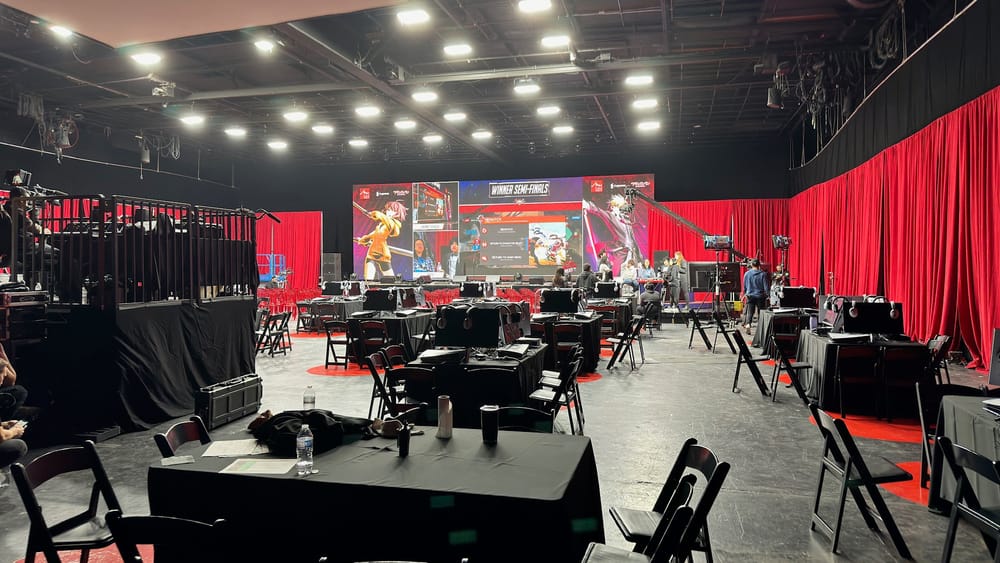 Arc World Tour Finals competition area prepared with stage screens, seating, and production equipment