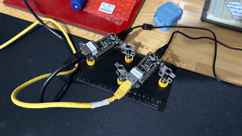 Two small development boards connected by Ethernet during a networked tally-light bench test