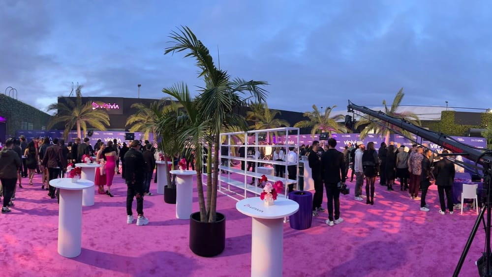 Wide view of the Vinivia Awards venue with guests and production cameras under magenta lighting