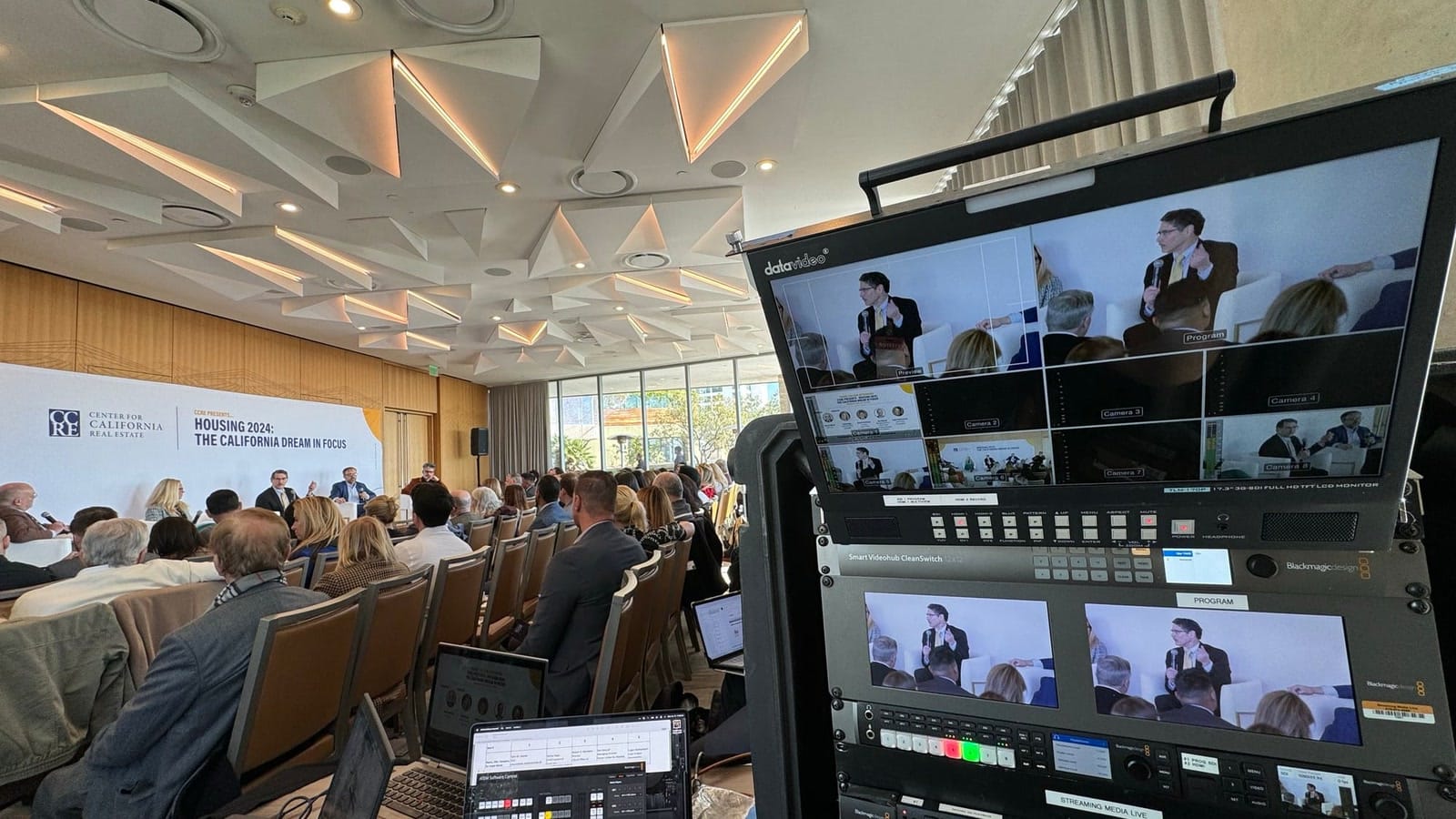 Camera, production monitors, and presentation screens arranged for a CCRE event